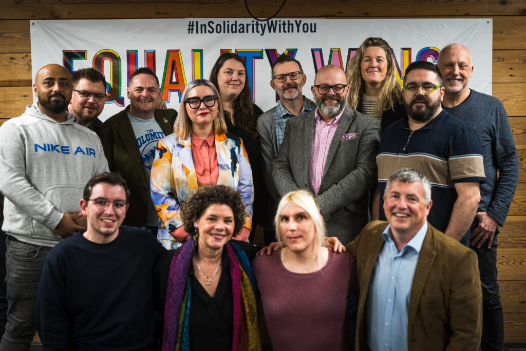 Group portrait of LGBT Foundation Trustees. All looking at camera, smiling.