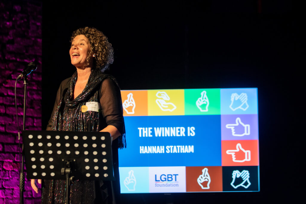 On stage, trustee speaker announcing a winner of volunteer award.